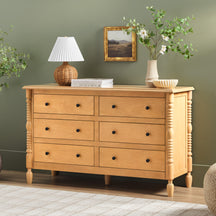 Wooden dresser with decorative items against a green wall